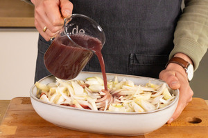 Rotwein und Rinderbrühe in die Auflaufform geben.