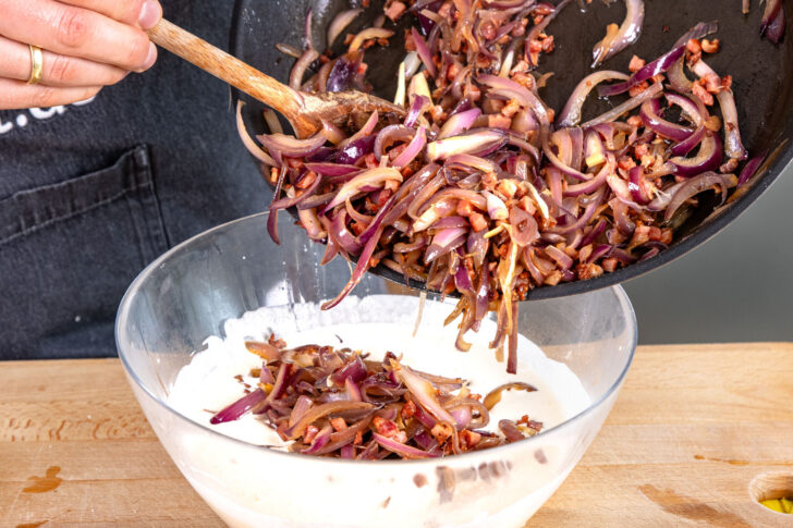 Zwiebeln und Schinkenwürfel zu Creme geben