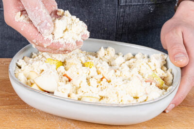 Crumble-Teig über dem Obst verteilen