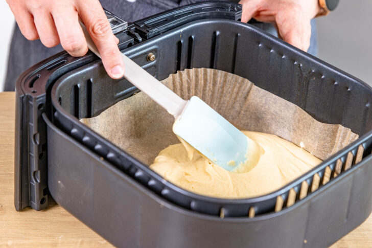 Kuchenteig in der Backform der Heißluftfritteuse verstreichen