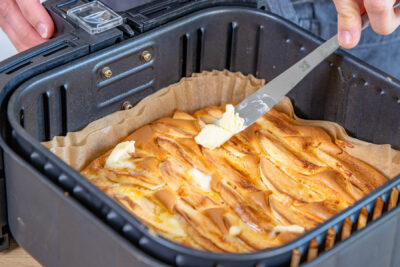 Butterflocken auf Apfelkuchen verteilen