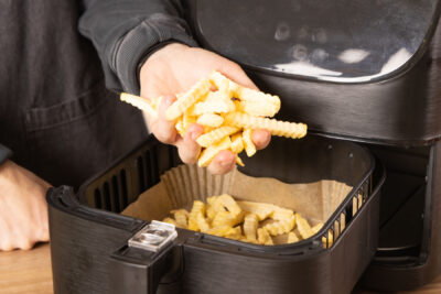 Pommes in die Heißluftfritteuse geben.