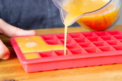 Orangensaft in Eiswürfel gießen