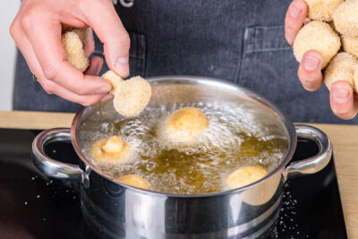 panierte Champignons im heißen Öl ausbacken