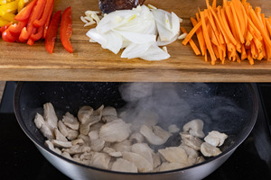 Das Gemüse in den Wok geben