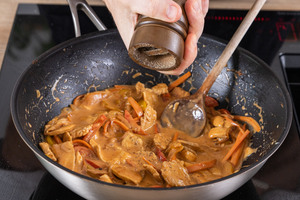 Hähnchencurry mit Reis und Gemüse würzen