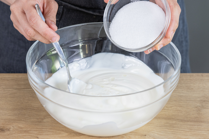 Joghurt, Zucker und Zitronensaft in einer Schüssel mischen
