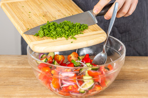 Gehackte Petersilie in Salat geben