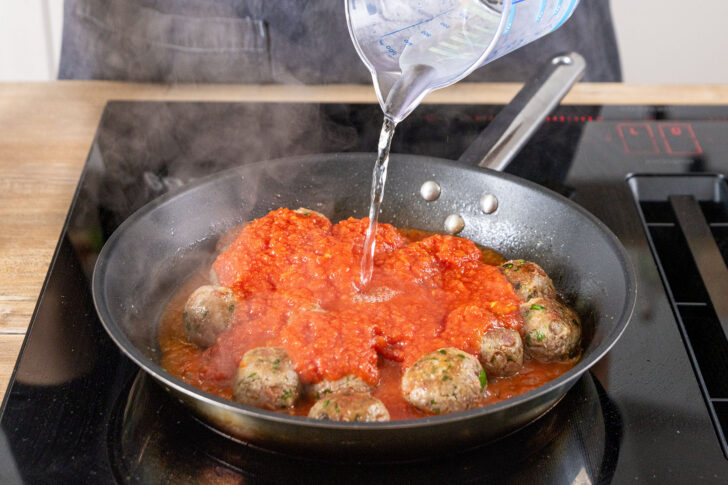 Wasser zu den gehackten Tomaten gießen