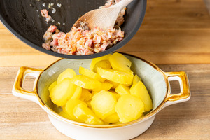 Angebratene Zwiebel und Speckwürfel in Auflaufform geben