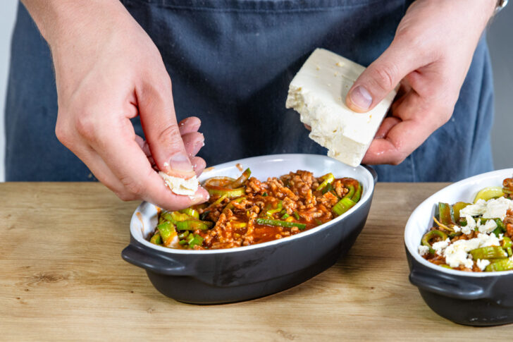 Feta über Kartoffelauflauf mit Hackfleisch bröseln