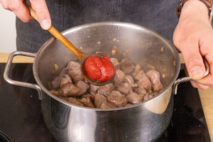 Tomatenmark zum Fleisch geben