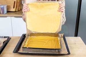 Mürbeteigdecke auf den Apfelkuchen geben