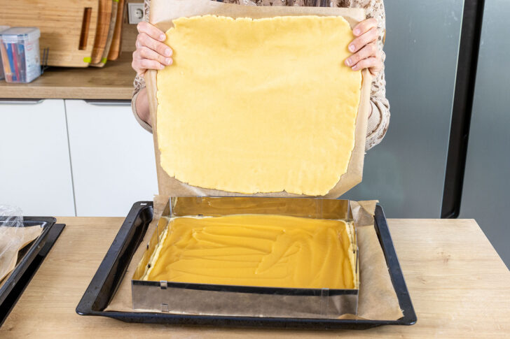 Mürbeteigdecke auf den Apfelkuchen geben