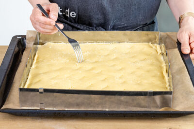 Omas gedeckten Apfelkuchen vom Blech mit einer Gabel einstechen