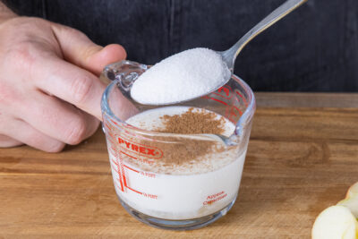 Zucker und Zimt in die Ei-Milch-Mischung geben