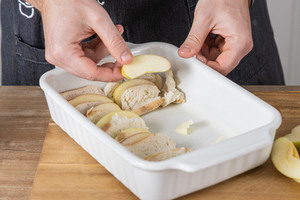 Brötchenscheiben und Apfelscheiben abwechselnd in eine Auflaufform geben