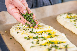 Pizzabrote mit Knoblauchöl besteichen und mit Kräutern bestreuen