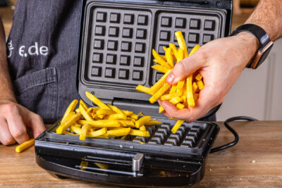 Pommes in das Waffeleisen geben