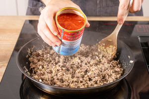 gehackte Tomaten zum Hackfleisch geben