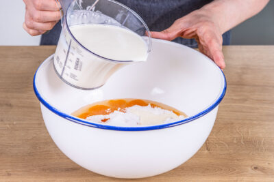 Milch in die Schüssel gießen