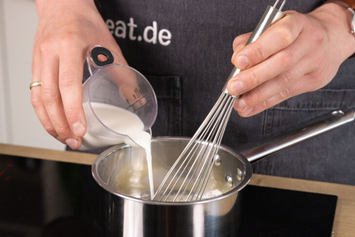 Milch in den Topf geben.