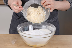 Mandeln, Vanillezucker, Puddingpulver und Bittermandelaroma in die Schüssel geben