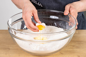 Ei und Butter zum Mehl geben