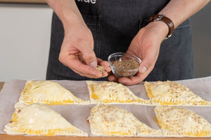 Blätterteigtaschen mit Sesam bestreuen