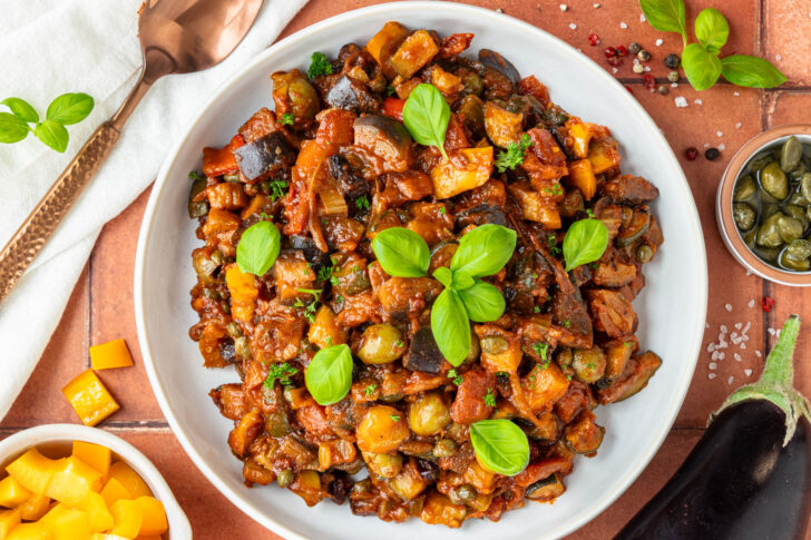 Angerichtete Caponata mit Basilikum aus der Vogelperspektive