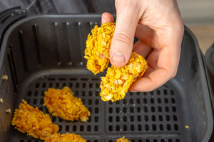 Chicken Nuggets in Korb der Heißluftfritteuse geben