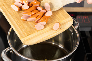 Bockwurstscheiben in Topf geben