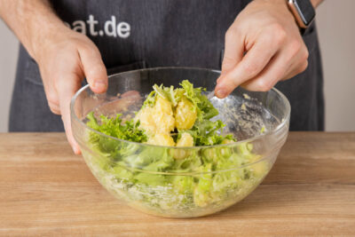 Salat und Kartoffeln vermischen