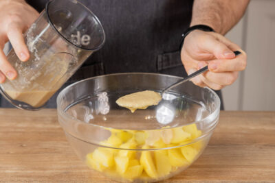 Dressing zu den Kartoffeln geben