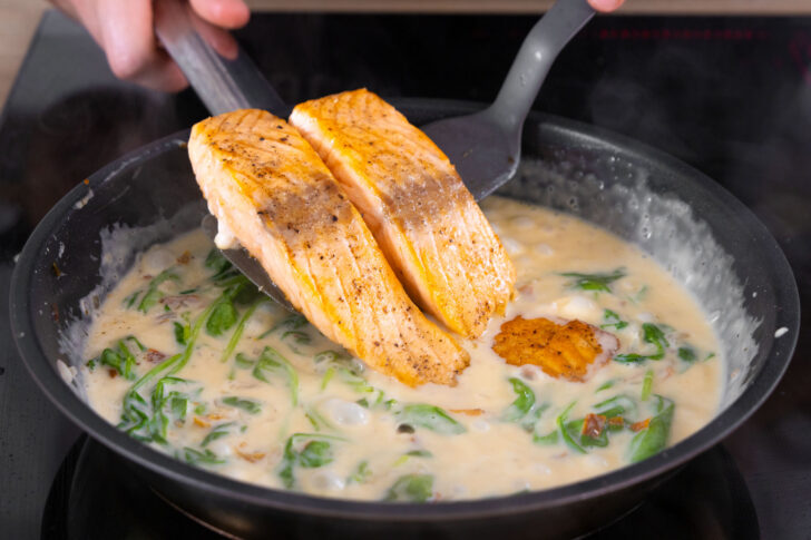 Den gebratenen Lachs in die Sahnesauce geben.