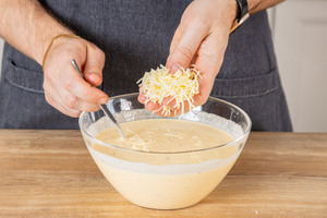 Geriebenen Gouda in Quarkmasse geben