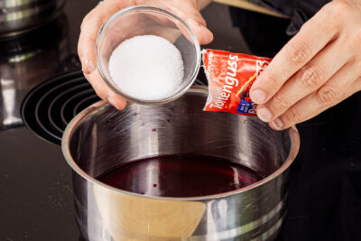 Kirschsaft mit Zucker und Tortenguss aufkochen