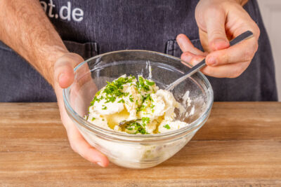 Frischkäse und Kräuter mischen