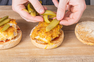 Gurken auf den Burger geben