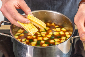 Parmesanrinde in Topf geben