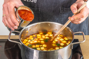 Dose gehackte Tomaten in den Topf geben