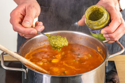 Grünes Pesto in Topf geben