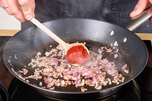 Tomatenmark zu angeschwitzten Zwiebeln geben
