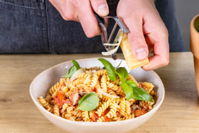 Parmesan über Nudeln mit Thunfisch hobeln