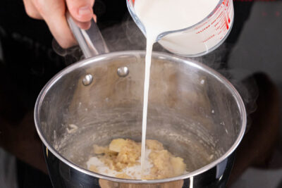 Milch zur Mehlschwitze gießen