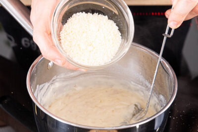 Parmesan in die Béchamelsoße rühren