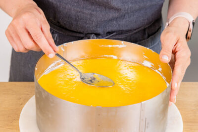Fruchtspiegel gleichmäßig auf Pfirsich-Joghurt-Torte auftragen