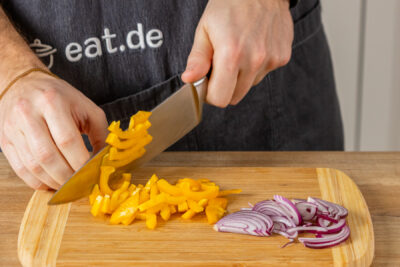 Paprika und Zwiebeln in Ringe schneiden
