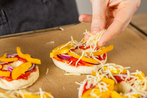 Geriebenen Käse über Pizzadonut streuen