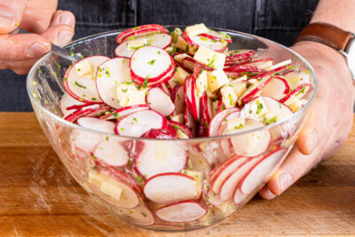 Radieschensalat mit Käse vermengen und abschmecken